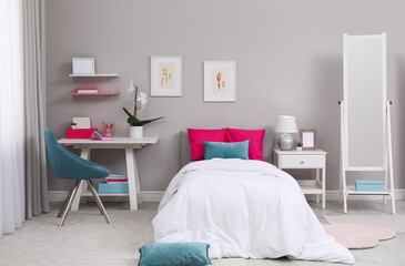 Modern teenager's room interior with comfortable bed and workplace