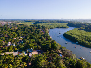 Fototapeta premium Vista aérea da vila de Caraíva em Porto Seguro, no sul da Bahia. Paraíso tropical com barcos e guarda-chuvas no pôr do sol tropical do Brasil.