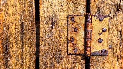 Grunge wooden board banner background with rusty iron hinge