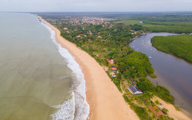 Vista aérea da vila de Caraíva em Porto Seguro, no sul da Bahia. Paraíso tropical com barcos e guarda-chuvas no pôr do sol tropical do Brasil.