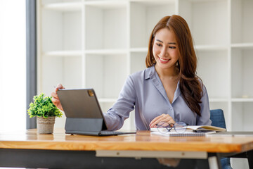 Portrait of smiling beautiful business asian woman with working in modern office desk using laptop computer, Business people employee freelance online marketing e-commerce telemarketing concept. - obrazy, fototapety, plakaty
