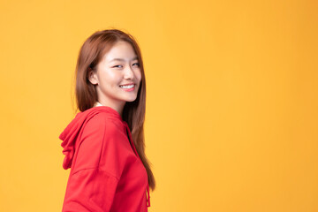 Fototapeta premium Portrait of beautiful young Asian girl model long hair in red coat summer clothes feeling smile, happy and enjoying in studio isolated on yellow background.