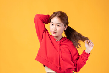 Portrait of beautiful young Asian girl model long hair in red coat summer clothes feeling smile, happy and enjoying in studio isolated on yellow background.