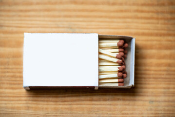 Cardboard box with matchsticks on wooden background, blank space top view. Space for design,flat...