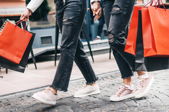 Photo of female legs stepping forward in shopping hands