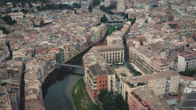 Aerial establishing shot of Girona city's buildings, architecture and river