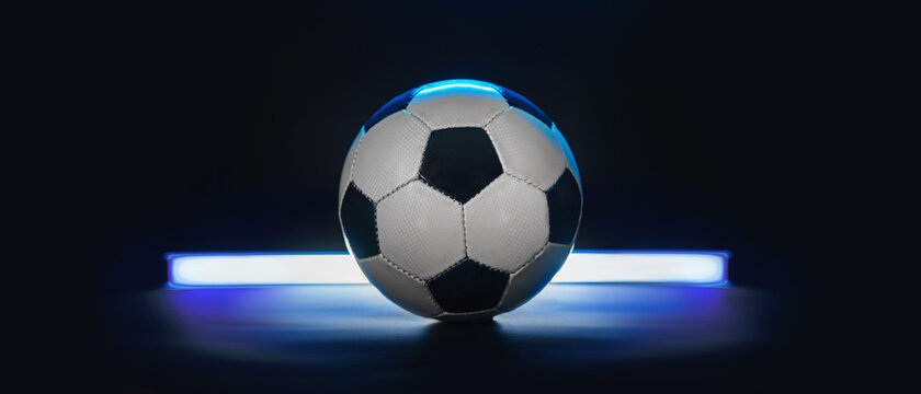  football or soccer ball against black background in neon light