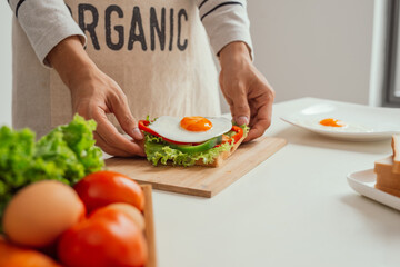 Obraz na płótnie Canvas Closeup image of a male cooking whole sandwich and vegetables salad
