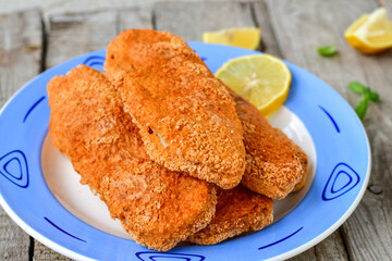  Fish and Chips/Close up of   crispy breaded  deep fried alaska pollock  fillets  with breadcrumbs served with remoulade sauce french fries  and   fresh lemons 
