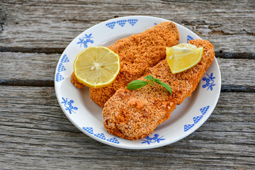 Fish and chips .Close up of   crispy breaded  deep fried fish fingers with breadcrumbs served with remoulade sauce and  lemon