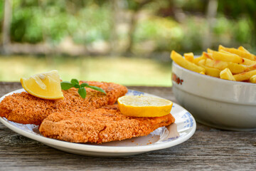  Fish and chips .Close up of   crispy breaded  deep fried fish fingers with breadcrumbs served with remoulade sauce and  lemon
