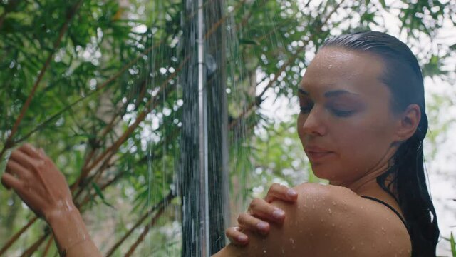 beautiful woman in shower wearing bikini washing body cleansing skin with refreshing water enjoying natural beauty spa showering outdoors in nature
