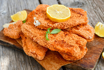  Fish and chips .Close up of   crispy breaded  deep fried fish fingers with breadcrumbs served with remoulade sauce and  lemon