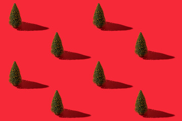 Green Christmas tree with black shadow on a red background. Pattern. Holiday.