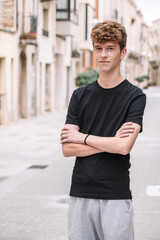 Teen boy with curly hair walking down the street