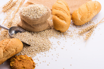Delicious organic bread with wheat ears and wheat grains There is space to copy text. On a white table top in a rustic kitchen - top view