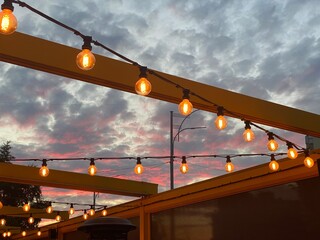 hanging light bulbs against the background of the evening sky in a summer cafe 