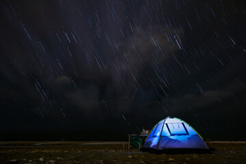 Night in tent on sandy beach under the stars