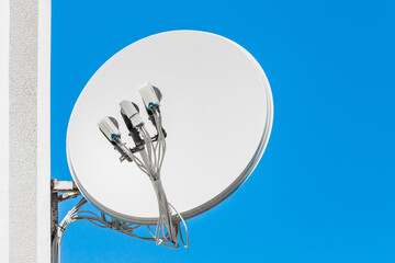 Satellite white dish antenna communication and tv signal technology on the wall of the house...