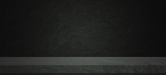 Empty dark stone tabletop or concrete shelf table on black wall background for montage product...