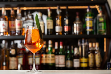 Glass of ice cold Aperol spritz cocktail served in a wine glass, decorated with slices of orange...