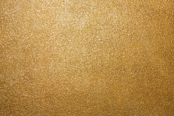 Golden rough surface covered with sequins. Beautiful festive pattern for holidays. Backdrop for Christmas text. Horizontal photo.