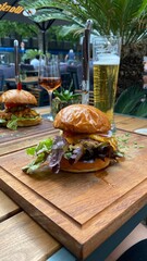 hamburger on a wooden table and beer on the background in restaurant