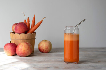 Apple carrot juice in a glass with a straw. Vitamin drink.