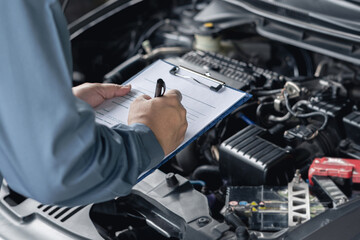 Close up hand car service staff check engine malfunctions and mistake check list in engine room : Car service concept