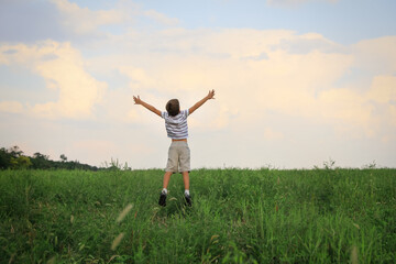 Little boy in field on sunny day, back view. Child spending time in nature © New Africa