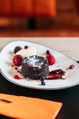 Chocolate lava cake served with berries on a white plate