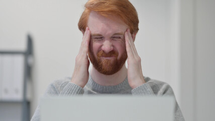 Beard Redhead Man having Headache while using Laptop 
