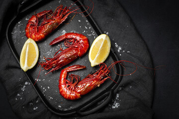 Scarlet shrimps with fresh lemon slices on tray