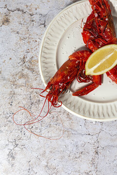 Scarlet shrimps with aromatic lemon pieces on plate