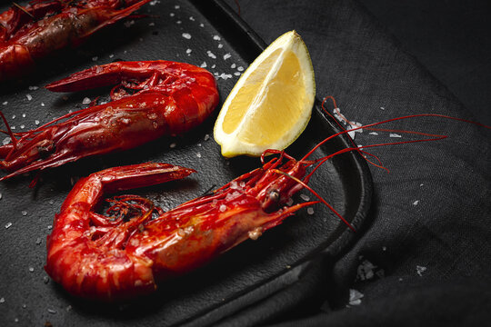 Scarlet shrimps with fresh lemon slices on tray