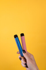 Female hand holding two vape sticks