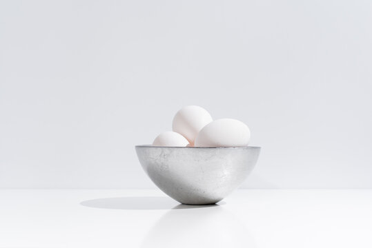 White chicken eggs in bowl on table
