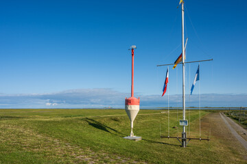 Signalmast am Sportboothafen Tümlauer Koog, im Hintergrund der Leuchtturm von Westerhever