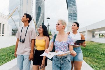 multiethnic group tourist friends outdoor using map sightseeing having fun together