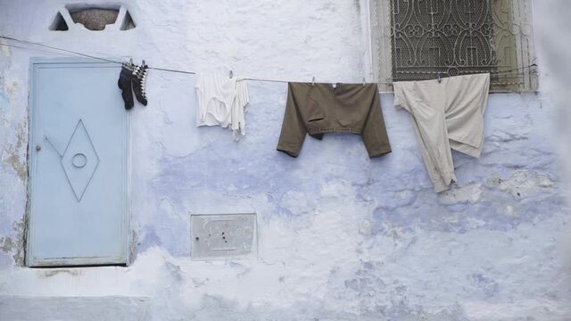 Ropa tendida en la puerta de una casa azul en la ciudad de Chefchaouen