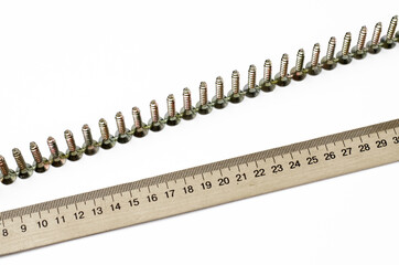 Self-tapping screws. Wooden ruler. Measuring tape. On white background.