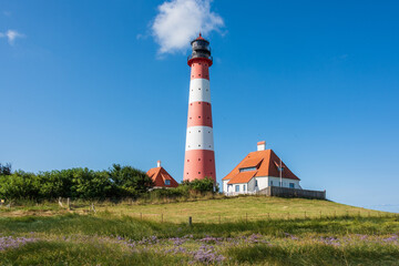 Fototapeta na wymiar Der Westerhefer Leuchtturm auf einer Warft im Wattenmeer, der Nordsee
