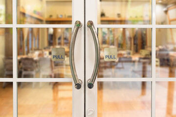 Restaurang door handle with pull sign on glass doors