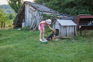  Little girl with domestic dog in backyard