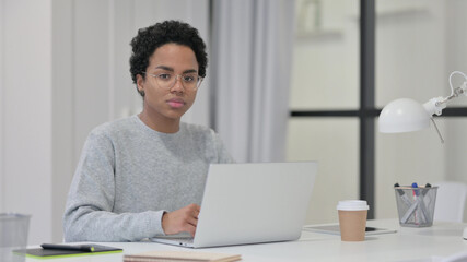 African Woman with Laptop Looking at Camera 