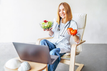 Female doctor nutritionist conducts online consultation with laptop.