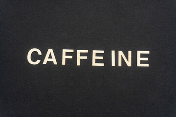 CAFFEINE word written on dark paper background. CAFFEINE text for your concepts