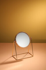 Fototapeta na wymiar Gold mirror on beige background. Vanity table concept. Minimal composition.
