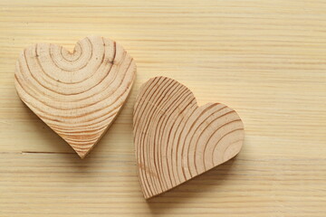 Fototapeta na wymiar Wooden hearts on a light background. Wooden hearts carved from wood. Painted wood background. 