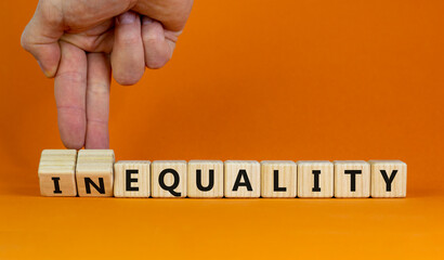Equality or inequality symbol. Businessman turns woden cubes, changes the word inequality to...